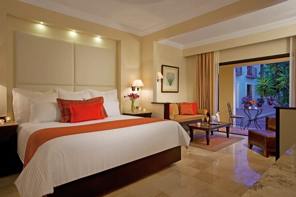 Deluxe Garden View Adults-Only junior suite with king bed and sitting area at Dreams Tulum Resort & Spa.
