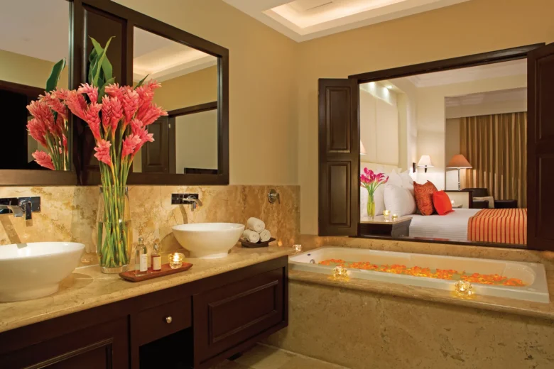 Deluxe Room bathroom with soaking tub and double vanity at Dreams Tulum Resort & Spa overlooking the suite bedroom.