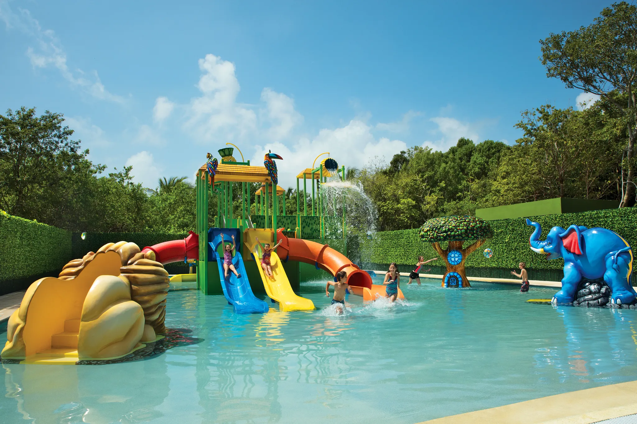 Children playing on colorful water slides at the Explorer’s Club water park at Dreams Tulum Resort & Spa.