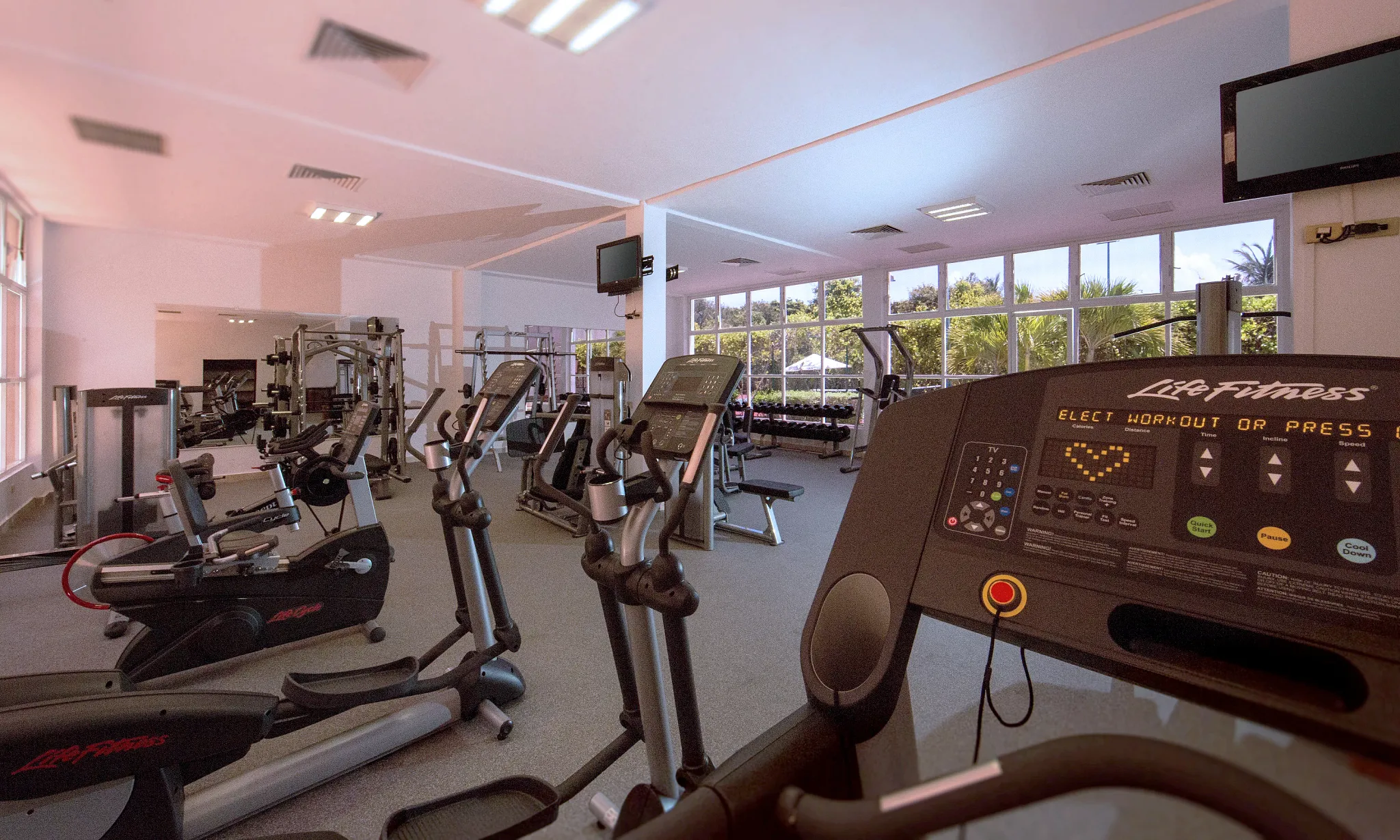 Modern fitness center with cardio and strength-training equipment at Dreams Tulum Resort & Spa.