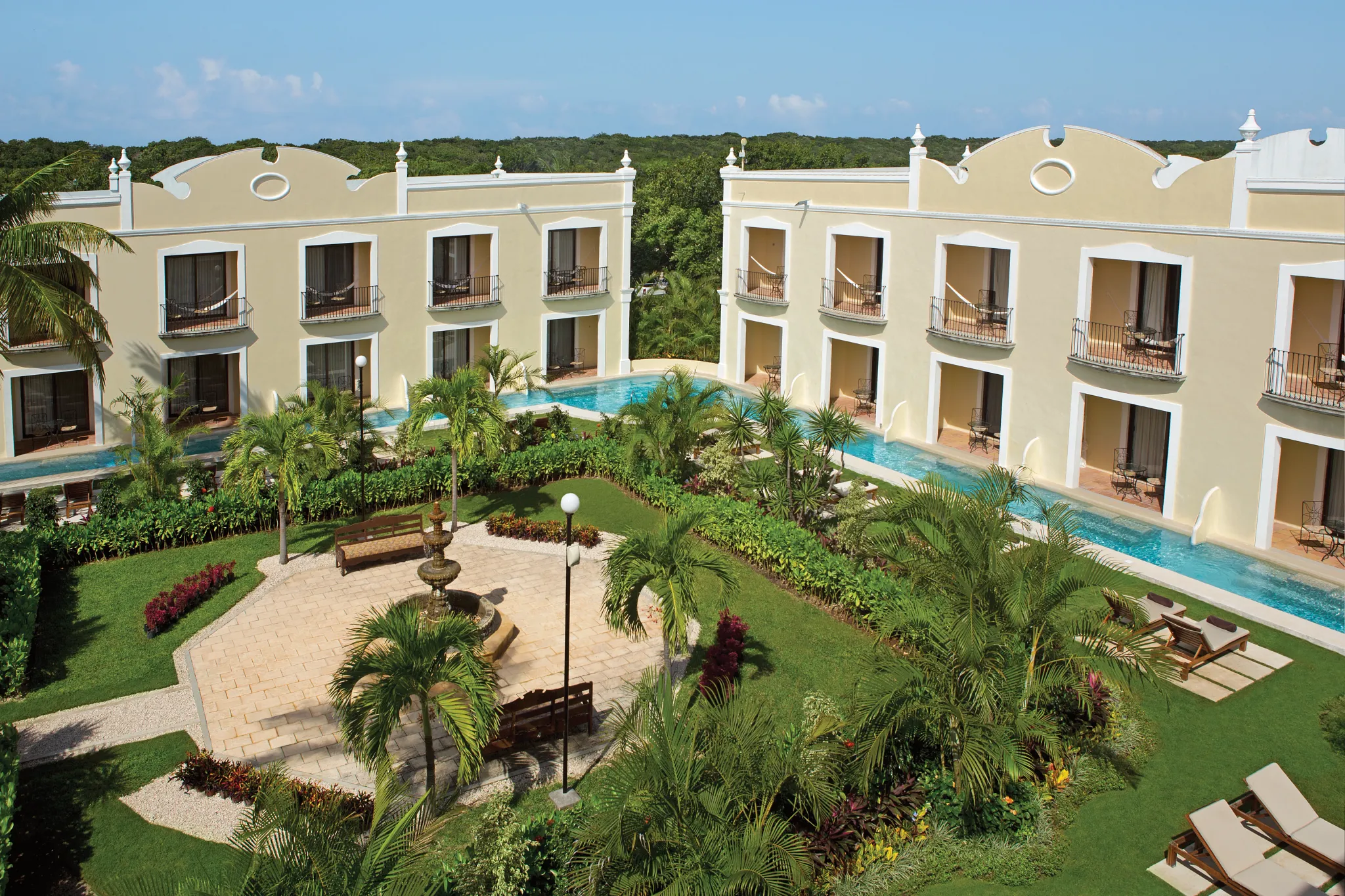 Aerial view of the adults-only swim-out suite section with heated pools and tropical gardens at Dreams Tulum Resort & Spa.