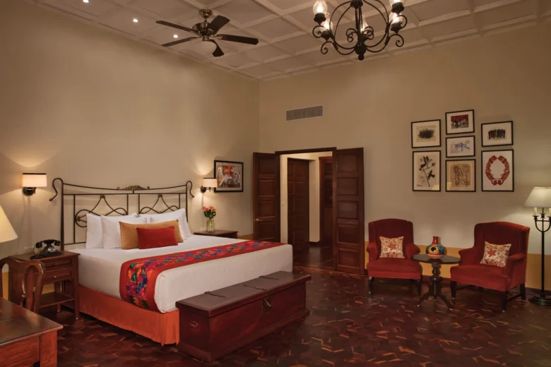 Preferred Club Hacienda Suite with king-size bed, elegant Mexican décor, sitting area, and high coffered ceilings at Dreams Tulum Resort & Spa.