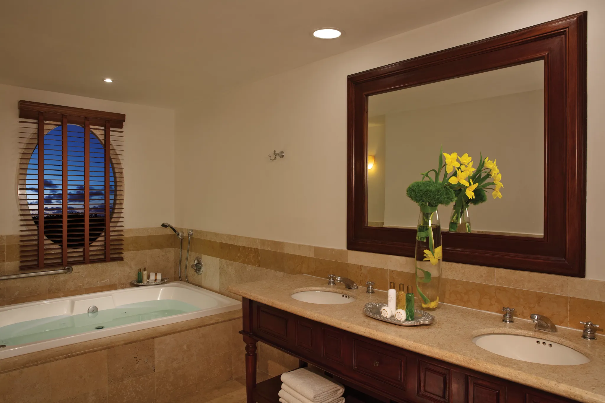 Marble bathroom with double vanity, soaking hot tub, and large framed mirror in the Preferred Club Honeymoon Suite Ocean Front at Dreams Tulum Resort & Spa.