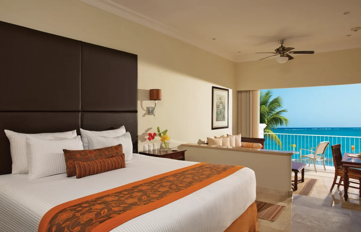 King bedroom in the Preferred Club Junior Suite Ocean Front with ocean views from a private furnished balcony at Dreams Tulum Resort & Spa.
