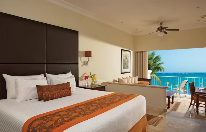 King bedroom in the Preferred Club Junior Suite Ocean Front with ocean views from a private furnished balcony at Dreams Tulum Resort & Spa.