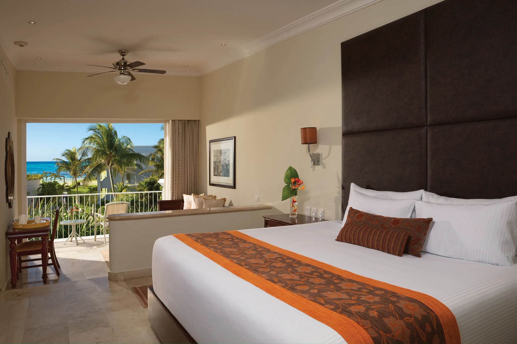 Preferred Club Junior Suite Ocean View king bedroom with balcony overlooking the ocean at Dreams Tulum Resort & Spa.